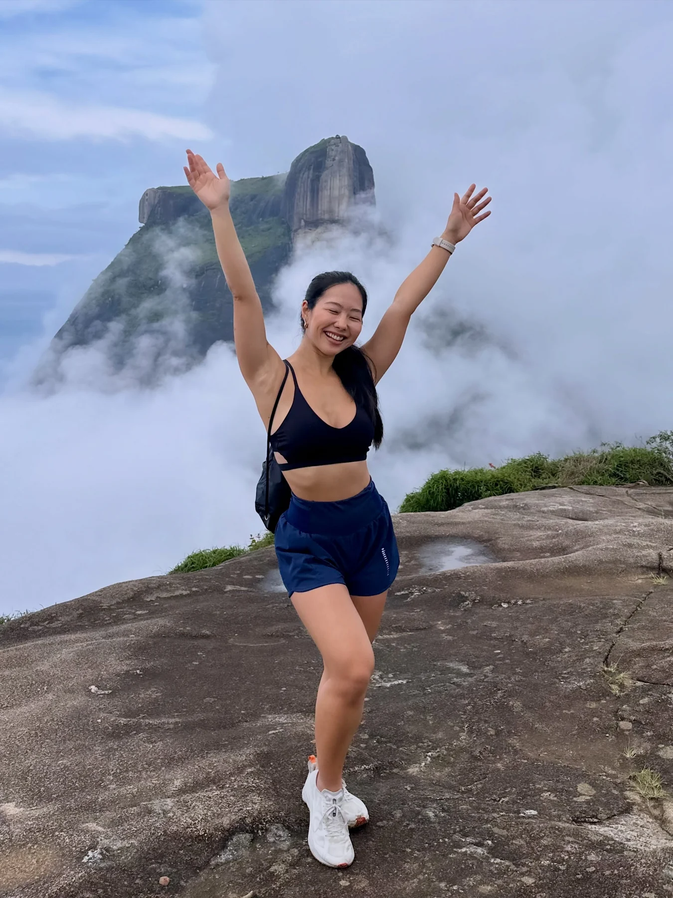 Marcella Emi celebrando uma trilha na montanha